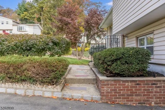 a front view of a house with a yard and potted plants