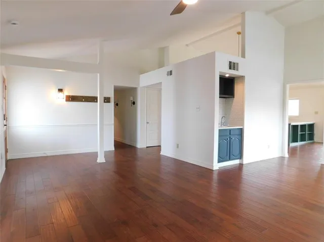 a view of a kitchen with a refrigerator and wooden floor