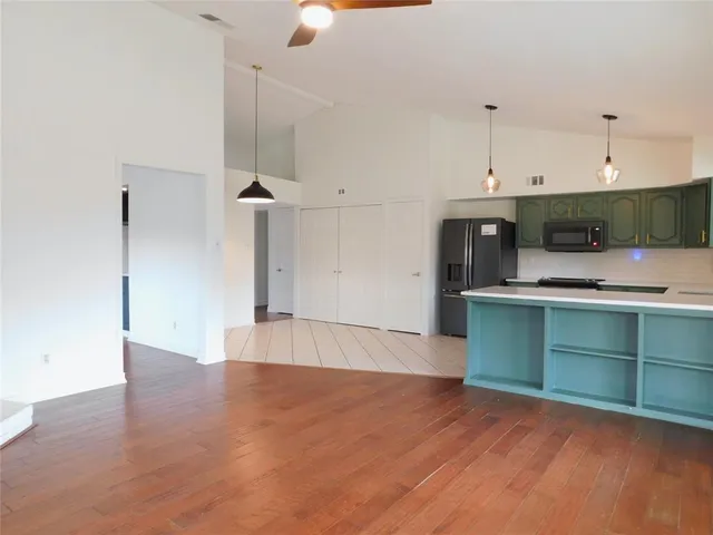 an empty room with wooden floor and cabinet