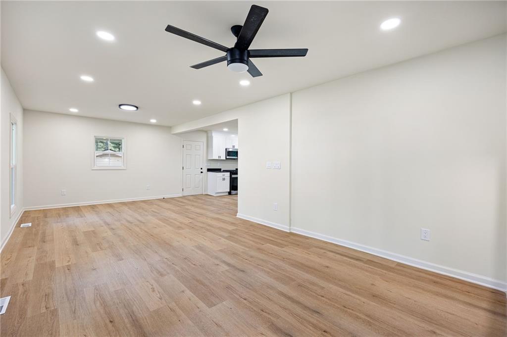 4289 Kimball Road Southwest Atlanta, GA 30331 - Photo 3 of 20 an empty room with wooden floor and a ceiling fan