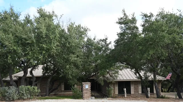 a front view of a building with trees