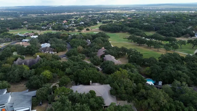 an aerial view of residential house with outdoor space and trees all around