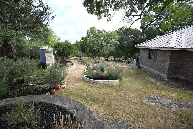 a view of a backyard with table and chairs and a large tree