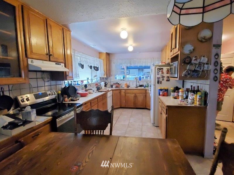 3368 Ray Williams Road Colville, WA 99114 - Photo 14 of 19 a kitchen with stainless steel appliances granite countertop a sink a stove and a wooden floors