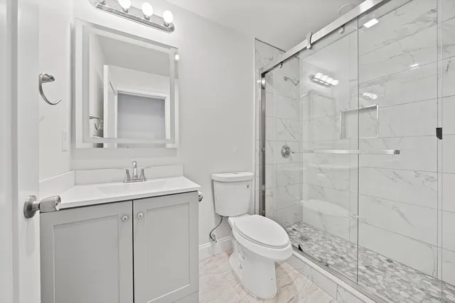 a bathroom with a toilet sink vanity and mirror