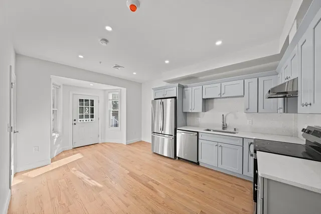 a kitchen with white cabinets and stainless steel appliances