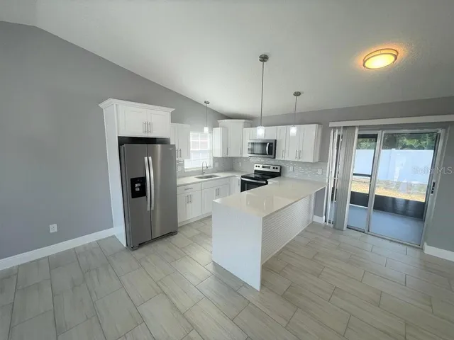 a large white kitchen with a stove a sink dishwasher and a refrigerator