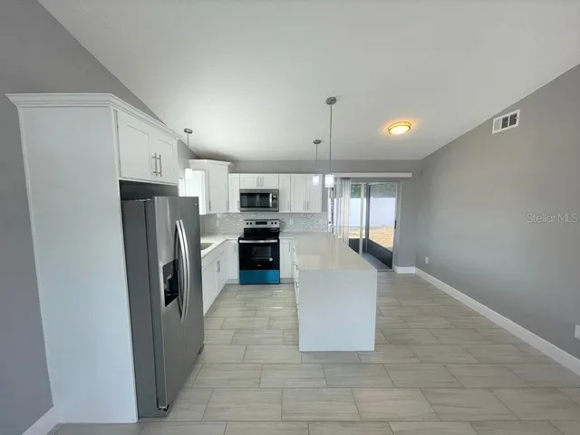 a kitchen with stainless steel appliances a refrigerator and a stove