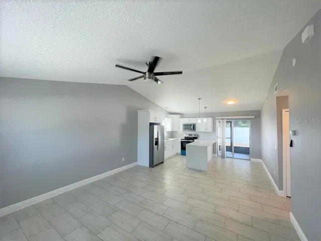 a view of a living room hardwood flooring and ceiling fan