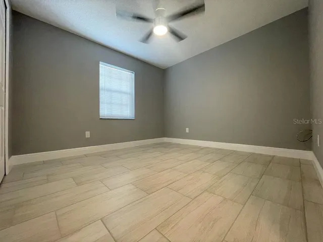 en empty room with windows and fan