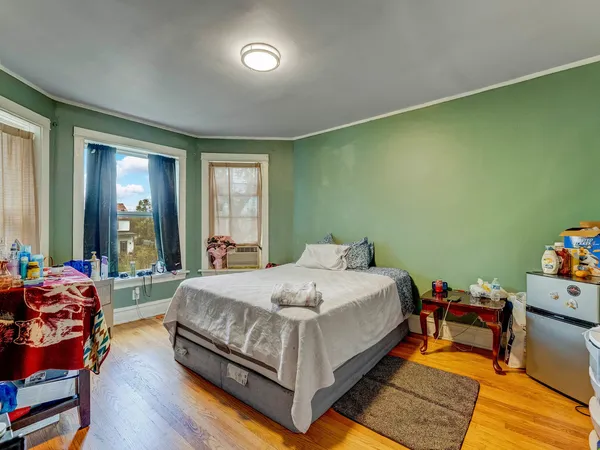 a bedroom with a bed and wooden floor