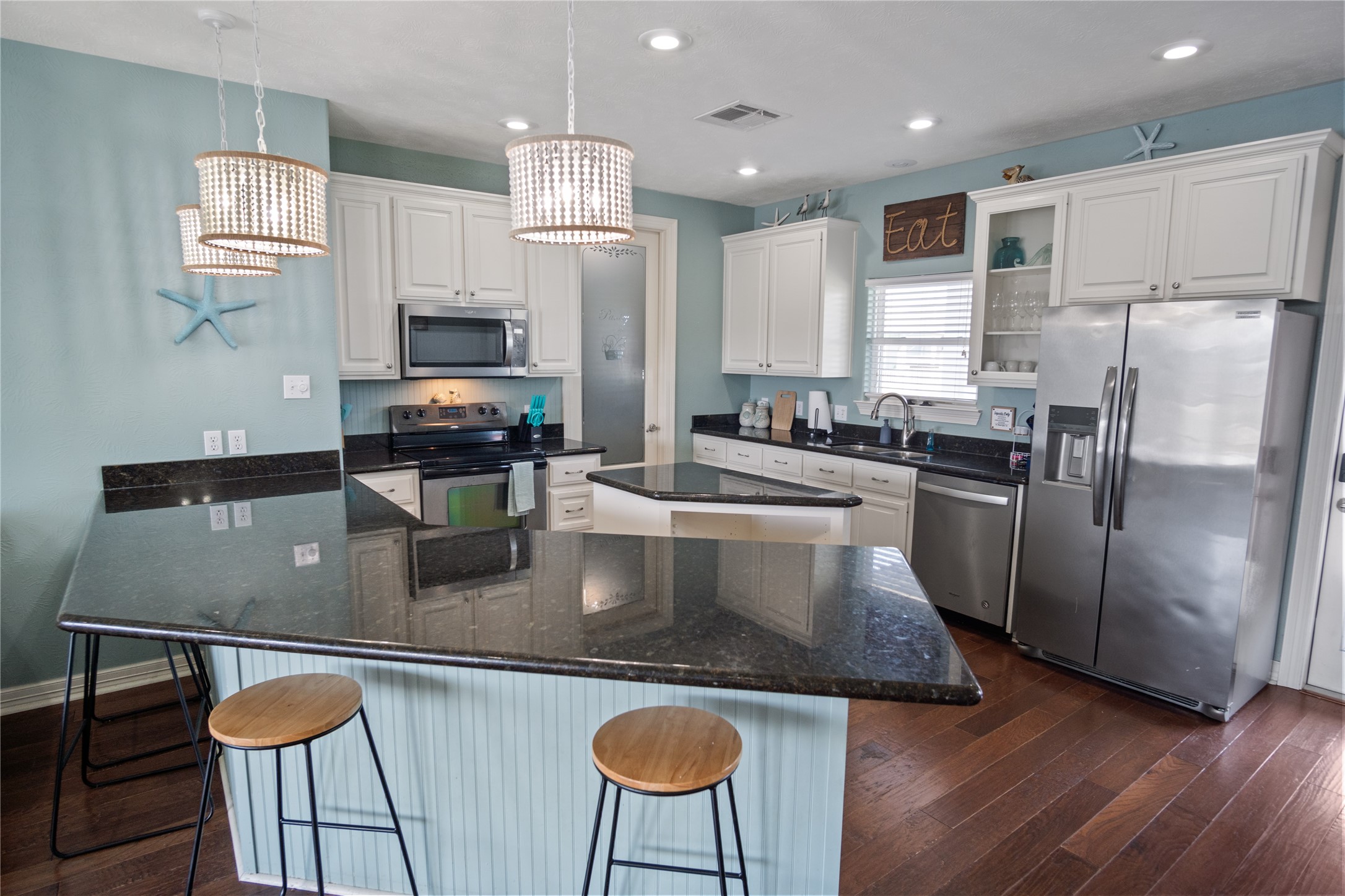932 Kent Crystal Beach, TX 77650 - Photo 8 of 37 a kitchen with stainless steel appliances a sink a stove a microwave a refrigerator and white cabinets
