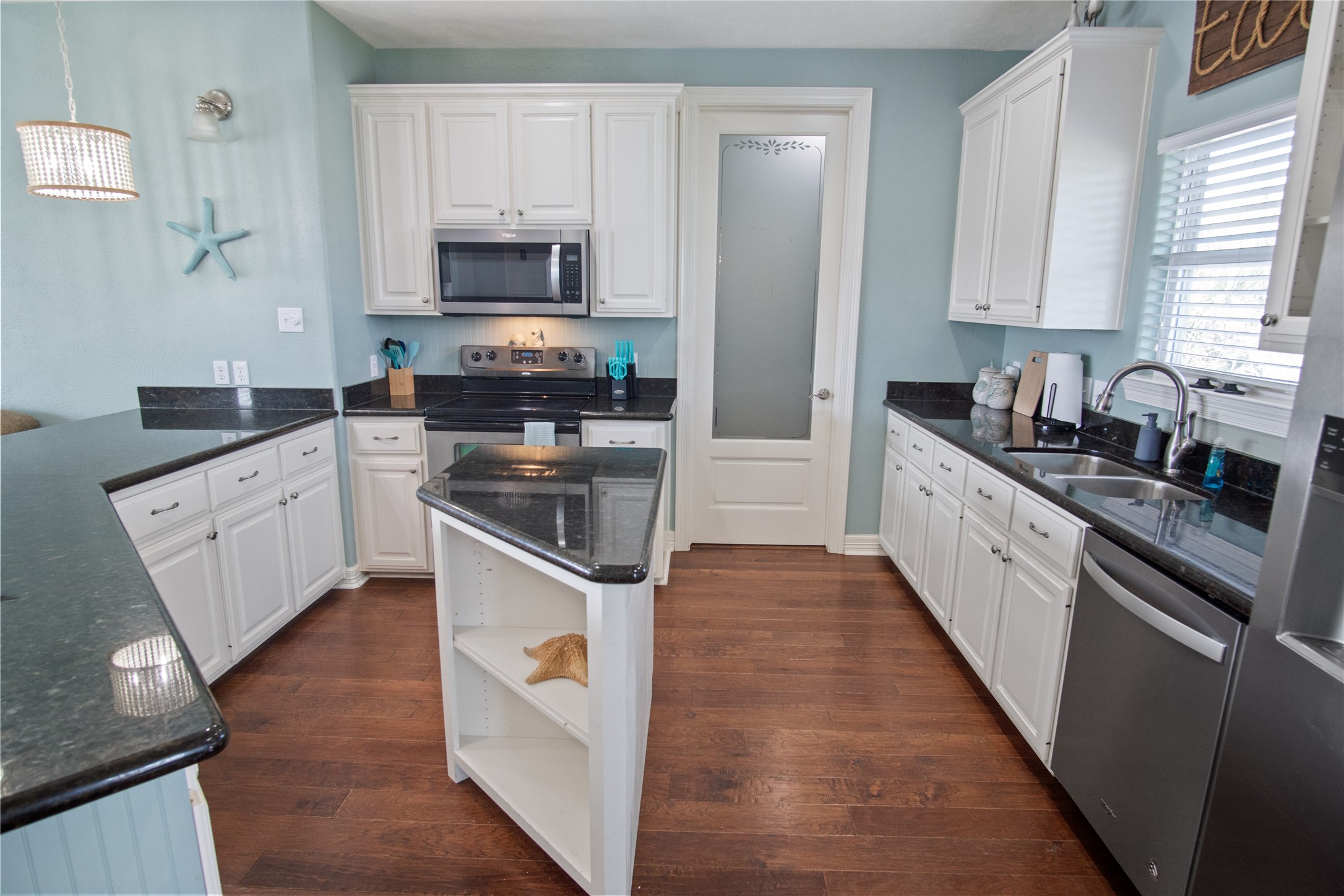 932 Kent Crystal Beach, TX 77650 - Photo 9 of 37 a kitchen with granite countertop a stove top oven sink and cabinets