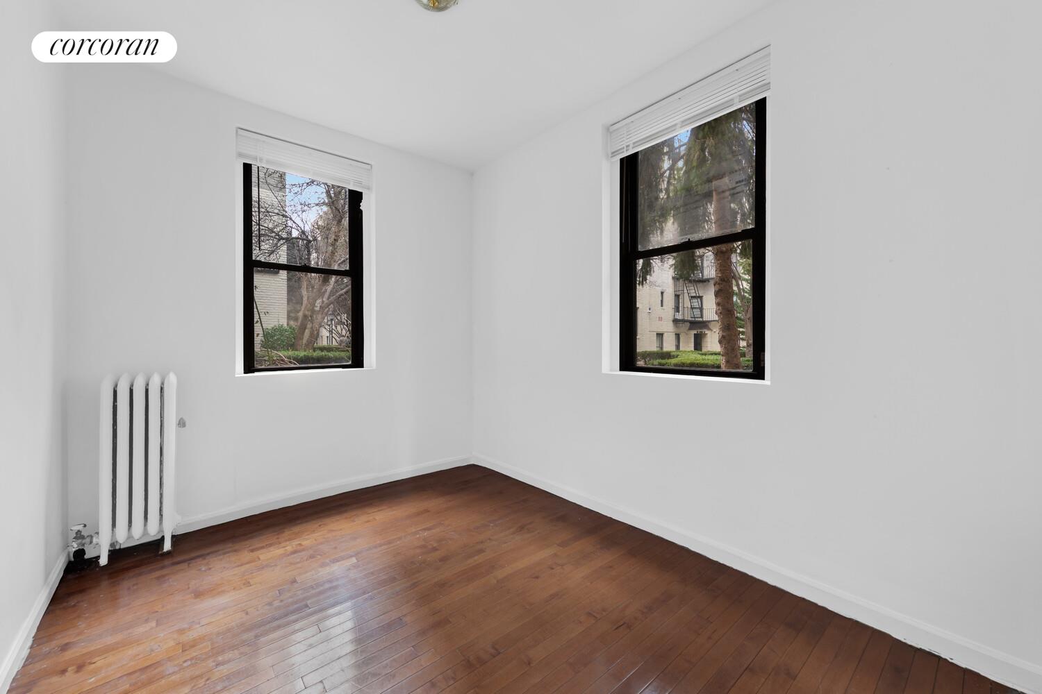 21-28 35th Street, Unit 1H Queens, NY 11105 - Photo 6 of 8 a view of an empty room with wooden floor and a window