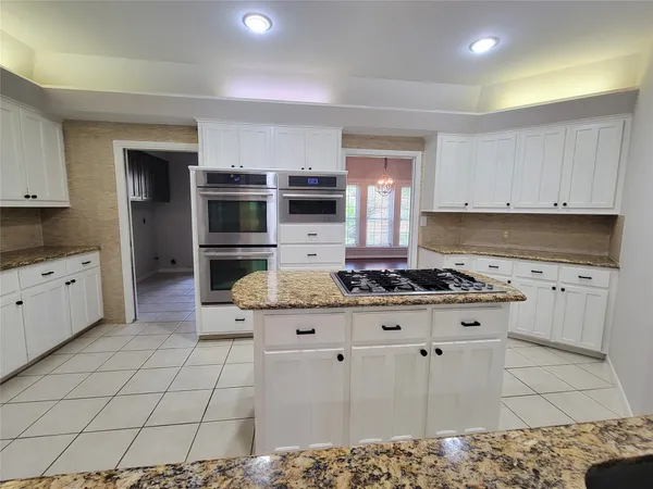 a kitchen with granite countertop a stove a sink and a refrigerator