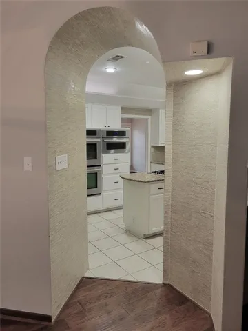 a kitchen with a refrigerator and white cabinets
