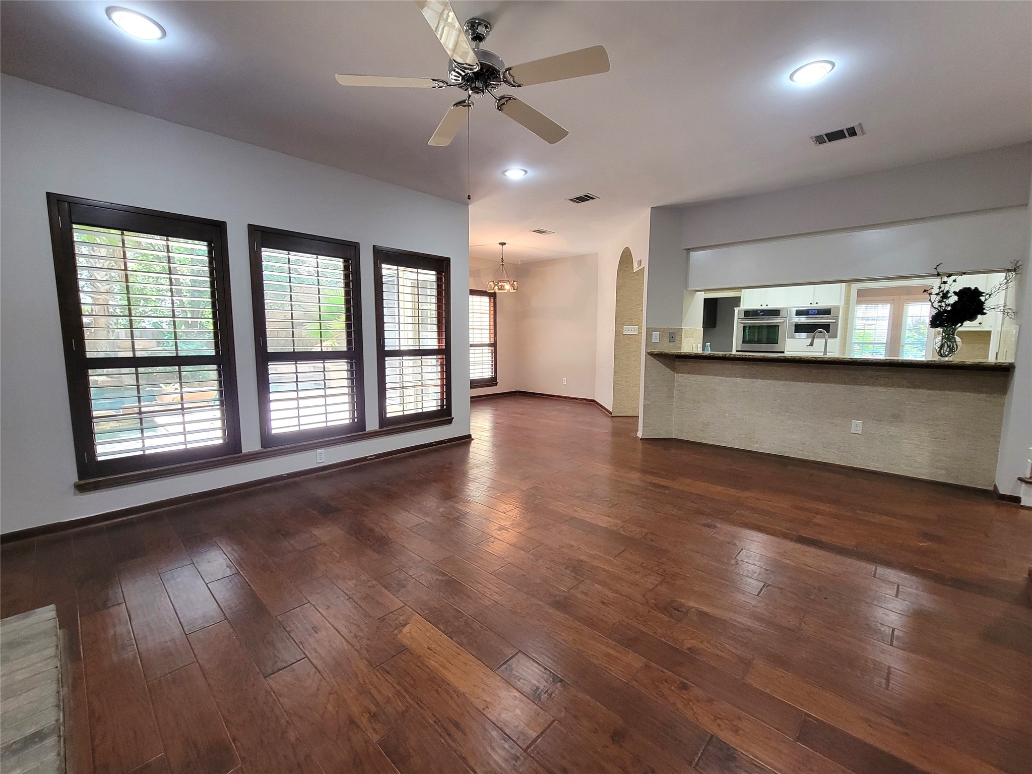 10 Dovewood Place The Woodlands, TX 77381 - Photo 18 of 34 an empty room with wooden floor chandelier and windows