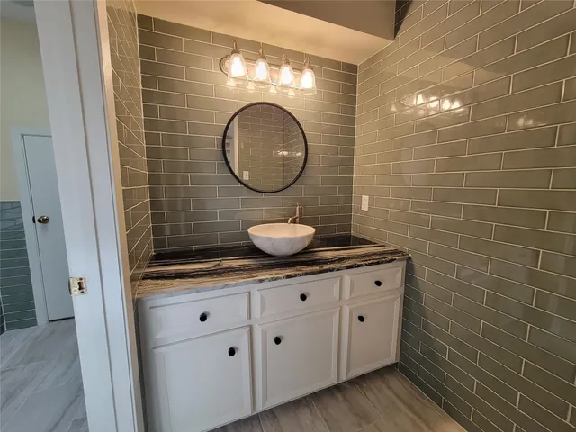 a bathroom with a granite countertop sink a toilet and a mirror