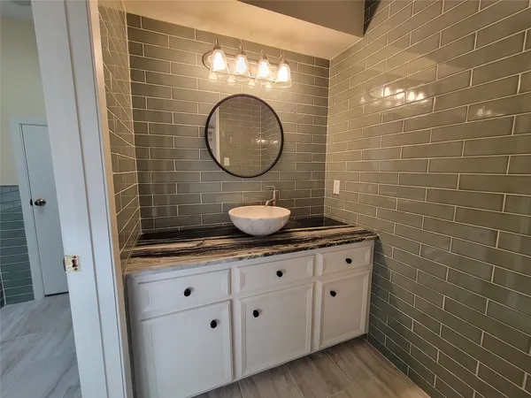 a bathroom with a granite countertop sink a toilet and a mirror