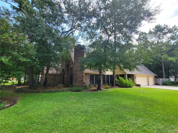 a view of a house with a big yard and large trees
