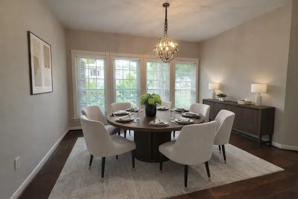 a view of a dining room with furniture a chandelier and wooden floor