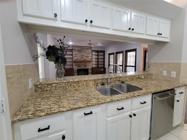 a kitchen with granite countertop a sink and cabinets