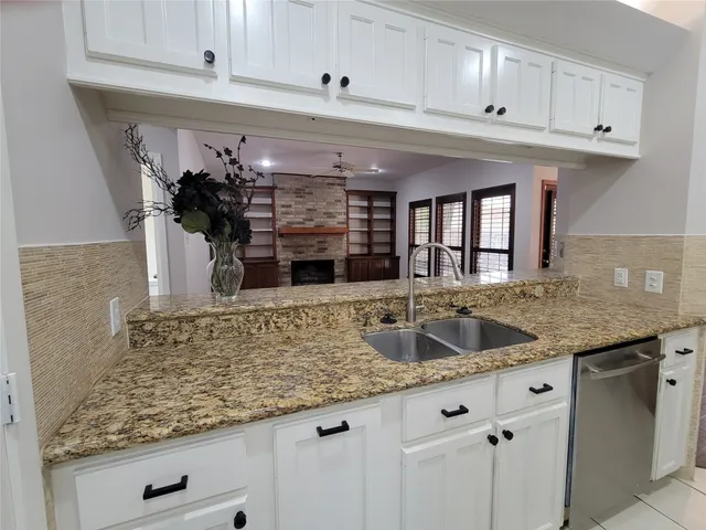 a kitchen with granite countertop a sink and cabinets
