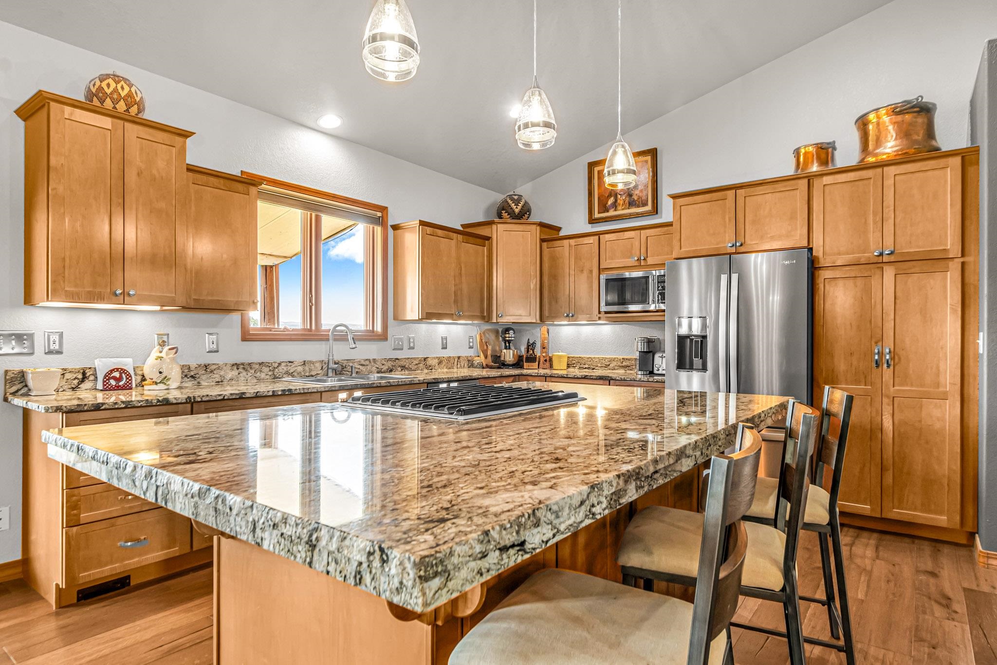 985-20 20 1/2 Road Fruita, CO 81521 - Photo 19 of 42 a kitchen with kitchen island granite countertop wooden cabinets granite counter tops and a view of living room