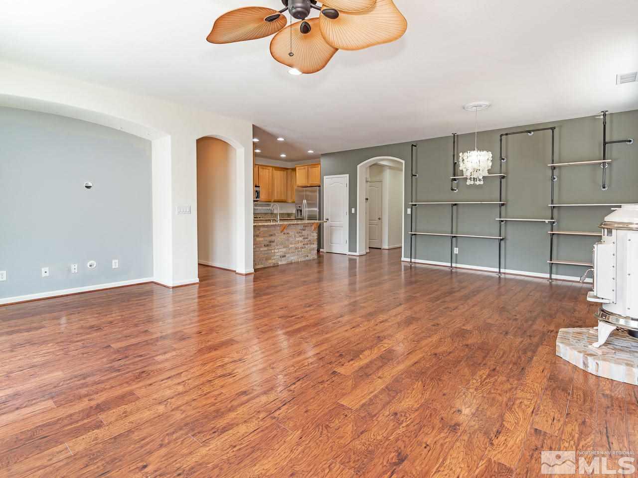 11390 Crotone Way Reno, NV 89521 - Photo 8 of 23 a view of an empty room with window and wooden floor