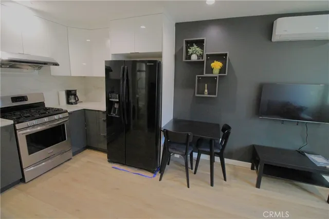a kitchen with a refrigerator and a stove top oven