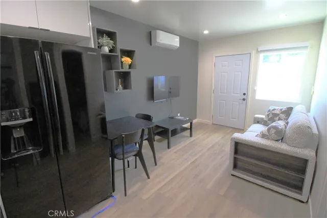 a living room with furniture and a refrigerator