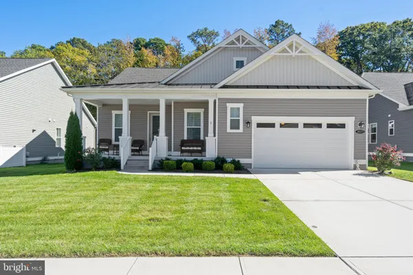 a view of a house with a yard and potted plants