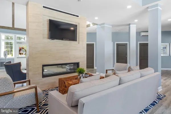 a living room with furniture a flat screen tv and a fireplace