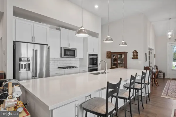 a large kitchen with a table chairs refrigerator and microwave