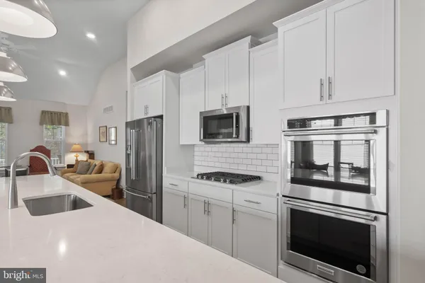 a kitchen with stainless steel appliances a stove microwave and refrigerator
