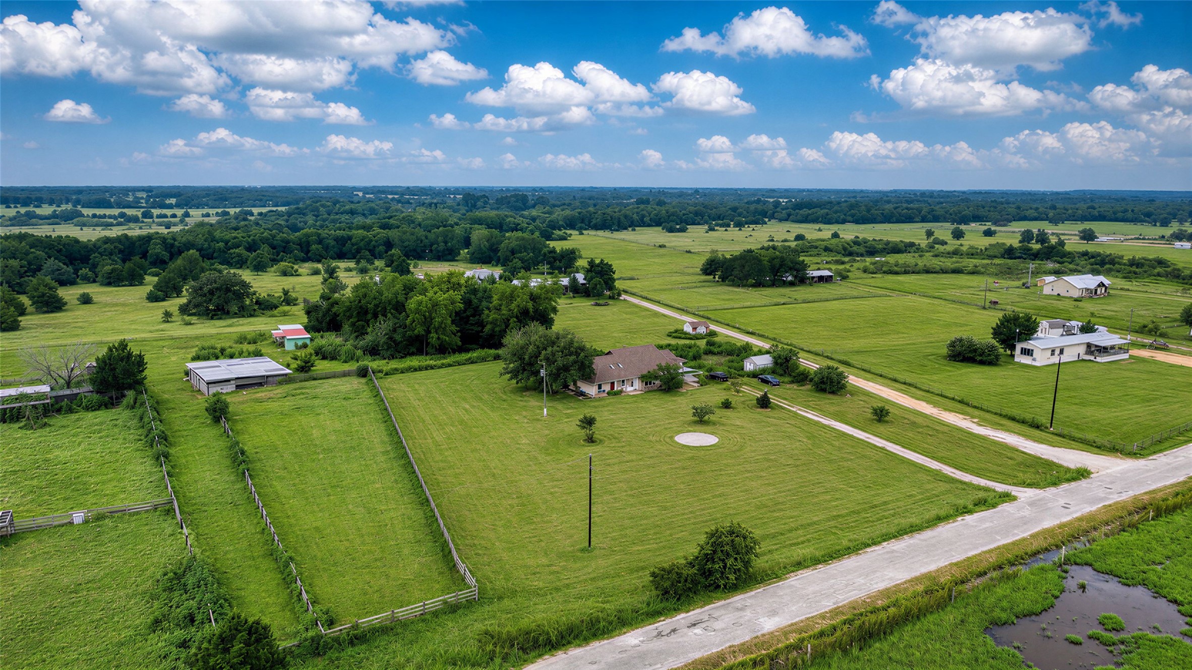 358 Easley Road Smithville, TX 78957 - Photo 33 of 36 An aerial perspective reveals a charming residence nestled amidst a verdant landscape with open fields.