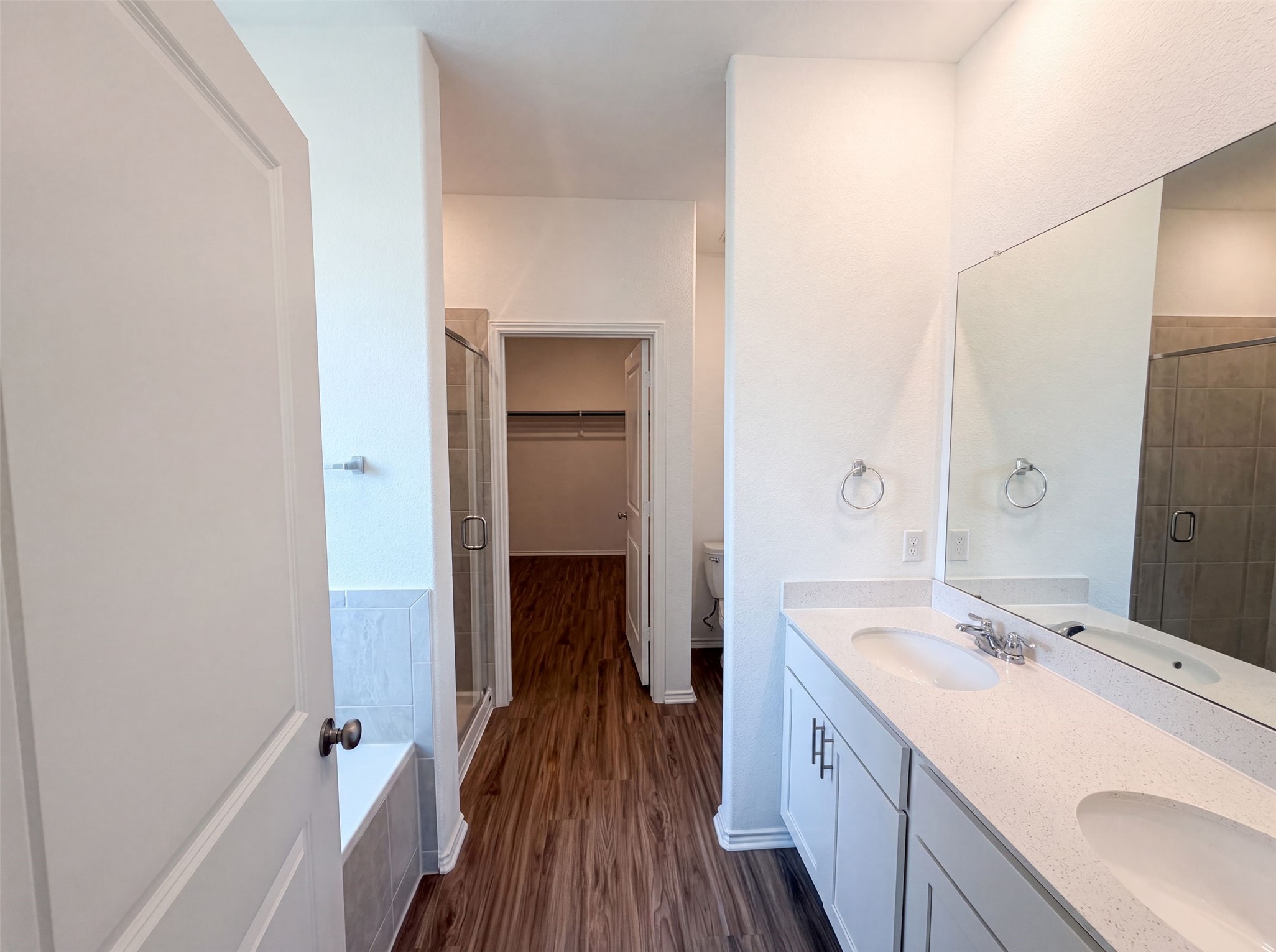 424 Wolf Springs Road Georgetown, TX 78628 - Photo 11 of 15 A well-appointed primary bathroom featuring a double vanity, a soaking tub, and a separate glass-enclosed shower.