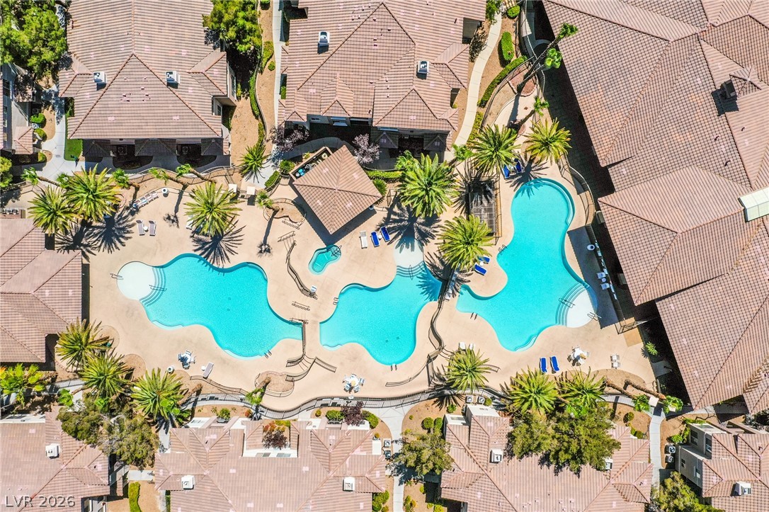 9050 West Warm Springs Road, Unit 1011 Las Vegas, NV 89148 - Photo 29 of 32 An aerial perspective reveals a resort-style aquatic oasis with multiple pools and lush landscaping.