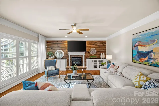 a living room with fireplace furniture and a large window