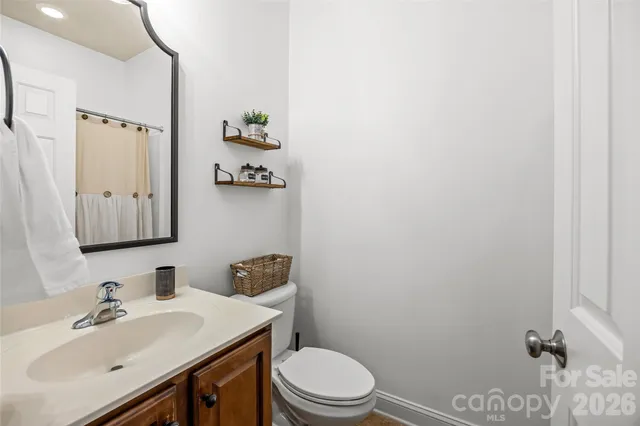 a bathroom with a sink vanity mirror and toilet