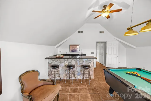 a living room with a table chairs and a chandelier