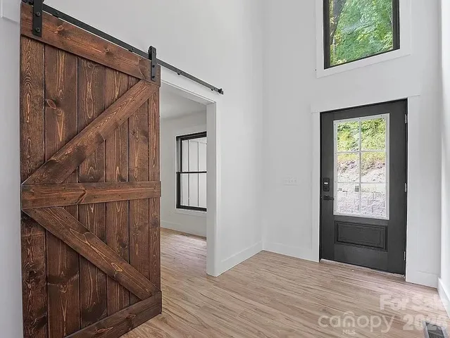 a view of entryway with wooden floor and front door