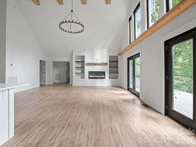 a view of empty room with wooden floor and fireplace