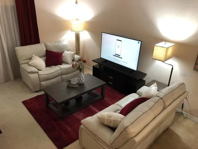 a living room with furniture a lamp and a flat screen tv