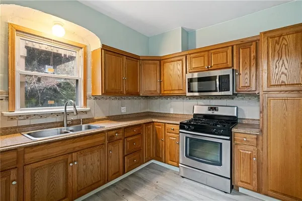 a kitchen with sink a microwave and cabinets
