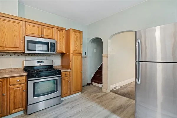 a kitchen with granite countertop a refrigerator stove and microwave