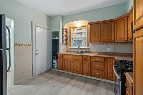 a kitchen with stainless steel appliances granite countertop a refrigerator and a sink