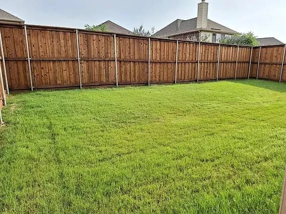a view of a backyard with wooden fence