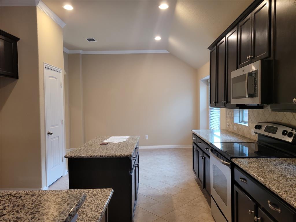 11821 Beach Street Frisco, TX 75036 - Photo 20 of 38 a kitchen with granite countertop stainless steel appliances and wooden cabinets