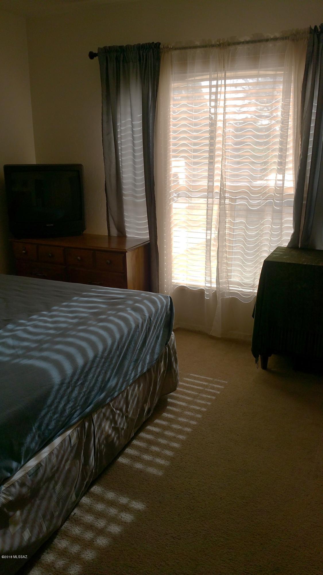 407 Willow Drive Rio Rico, AZ 85648 - Photo 14 of 15 a spacious bedroom with a bed and a window